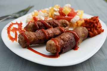 Chevapchichi. Meat sausages with vegetable salad, ketchup and adjika on white plate. Dish of Balkan cuisine.