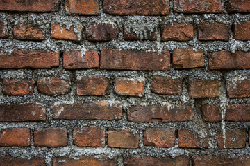 old dirty red brick wall with light cement. rough surface texture. stains of cement on the wall