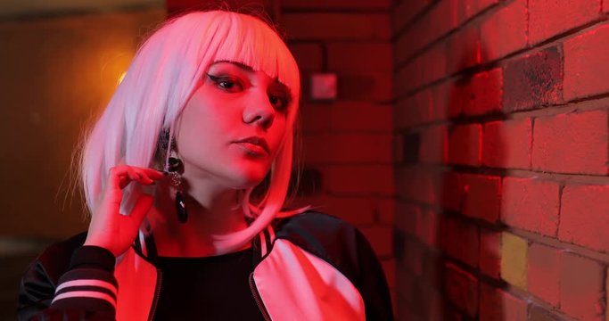 Sexy unusual girl in white wig primping in front of the mirror