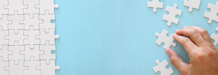 banner of male hand putting the last piece in the puzzle.
