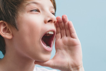 Boy screams with his hand near his mouth