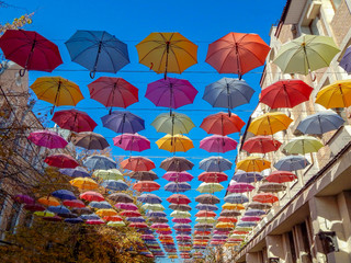Fototapeta na wymiar colorful umbrellas soaring hanging in the blue sky