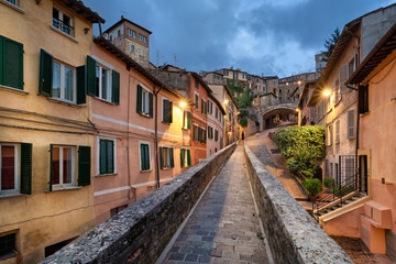Perugia, Italy. Medieval aqueduct and colorful buildings at dusk - obrazy, fototapety, plakaty
