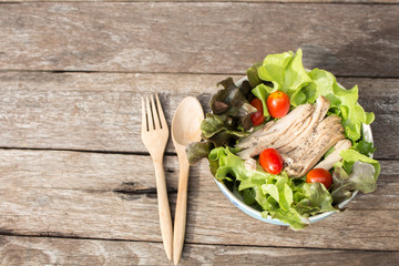 Vegetables salad with chicken on wooden background