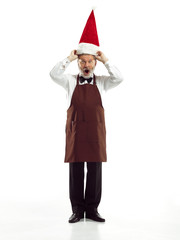 Portrait of Man in Santa Claus Costume - with a Luxurious White Beard, Santa's Hat and a Red Costume at red studio background