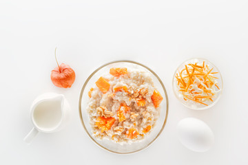 Oatmeal with pumpkin and nuts, salad, apple and jug of milk on a white background. Top view
