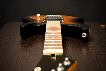 Electric guitar fretboard. On the background of a wooden table. Strings are missing.