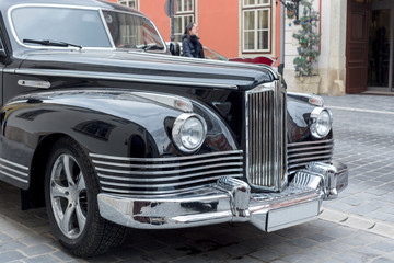 Black old school vintage car parked in old Budapest city street