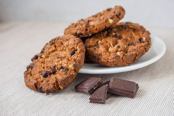 Chocolate chip cookies on white background. Stacked chocolate chip cookies on brown napkin. Symbolic image with place for text. Freshly baked. Concept for a tasty snack. Sweet dessert. 