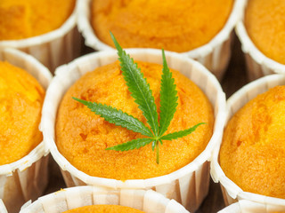 Delicious homemade baked cinnamon muffins with marijuana leaf garnish. Cookies with cannabis and buds. Treatment of medical marijuana for use in food.