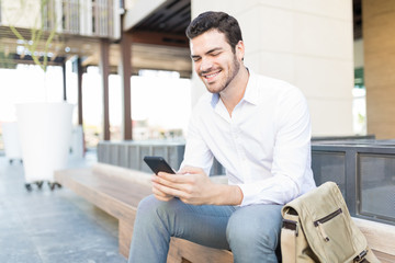 Executive Smiling While Reading Message On Smartphone