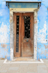 Fototapeta na wymiar Insel Burano bei Venedig: Verwitterte Hausfassade mit renovierungsbedürftiger Tür 