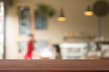 Wooden desk with Blurred of coffe's shop for abstract background