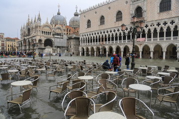 Venedig bei Hochwasser: Leere Tische und Stühle im Wasser am Markusplatz gegenüber dem Dogenpalast und Basilica San Marco