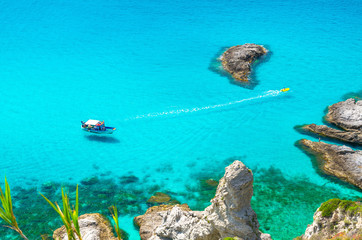 Fishing yacht and rubber boat in Capo Vaticano lagoon, Calabria, Italy
