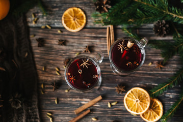 two glasses of mulled wine with cinnamon, star anise, cardamom and orange. Cocktail on wooden table...