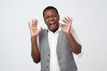Disgusted young african american man grimacing, looking in terror and disgust