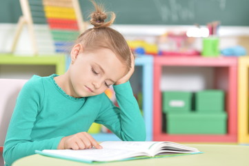 Portrait of a cute happy schoolgirl studying