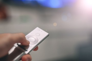  switch TV channels with modern remote control. watching a movie at home.