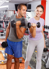 Couple doing exercises with dumbbells
