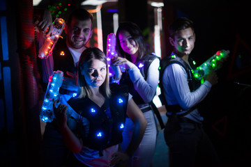 Friends with laser guns in lasertag room