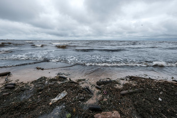 dirty beach by the sea with storm clouds above