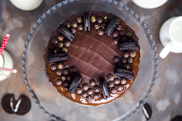 Decoration on a chocolate cake of biscuits and gold-covered chocolate drops. Top view. Flat lay