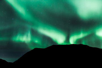 Fototapeta na wymiar Amazing northern lights in North Norway (Kvaloya), mountains in the background