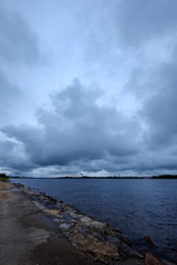 dirty beach by the sea with storm clouds above