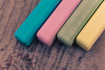Retro colored chalk sticks on old wood board as copy space background