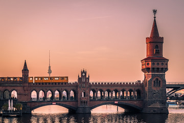 Fototapeta premium Oberbaum Bridge w Berlinie o zachodzie słońca z widokiem na wieży telewizyjnej