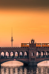 Naklejka premium Oberbaum Bridge w Berlinie o zachodzie słońca z widokiem na wieży telewizyjnej