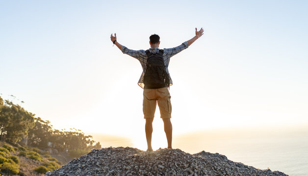 Hiker With Arms Outstretched On Hill Top