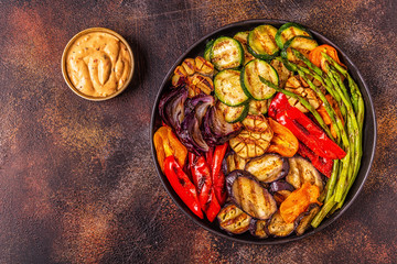 Grilled vegetables on a plate with sauce.