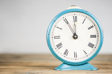 vintage alarm clock on wooden table over white background