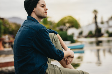 Man sitting beside a lake and relaxing