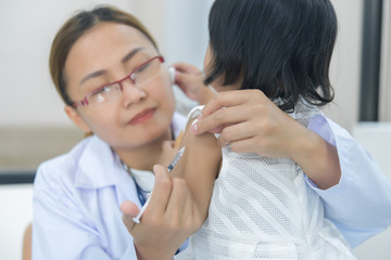 Obraz na płótnie Canvas Asian doctor using a stethoscope to check his breathing and heart of a lovely girl, check the health of children,Thailand people