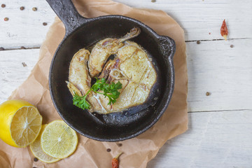 Oven cooked black cod with spices and parsley. Healthy food. Light white wooden background, top view