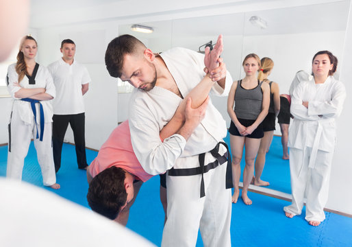 Coach showing new submission hold in taekwondo class