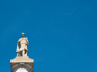 Eine Statue auf einer Säule vor wolkenlosen Himmel