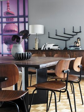 Classic wooden chairs around dining table, table lamp and candelabra on sideboard and view of television tower through window