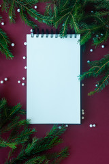 Christmas holidays composition on red background with fir tree and copy space for your text.