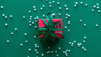 Christmas gift box. Christmas present in red box on green background.