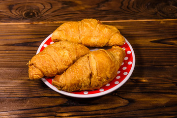 Plate with croissants on a wooden table