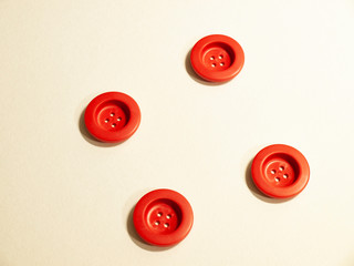 Four red buttons on white background.