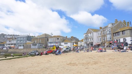 Families enjoying the golden sands of St Ives beach on a summer day.