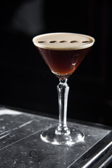 Espresso Martini cocktail on a bar desk. black background.