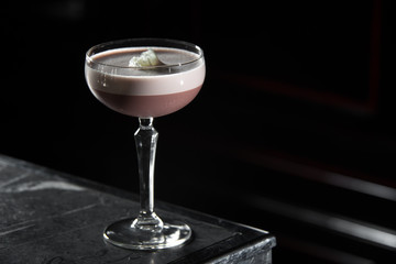 Porto Flip cocktail on a bar desk. black background