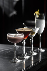 four special cocktails on a bar desk. black background