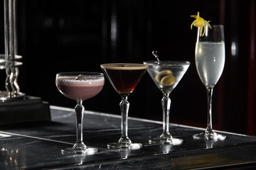 four special cocktails on a bar desk. black background